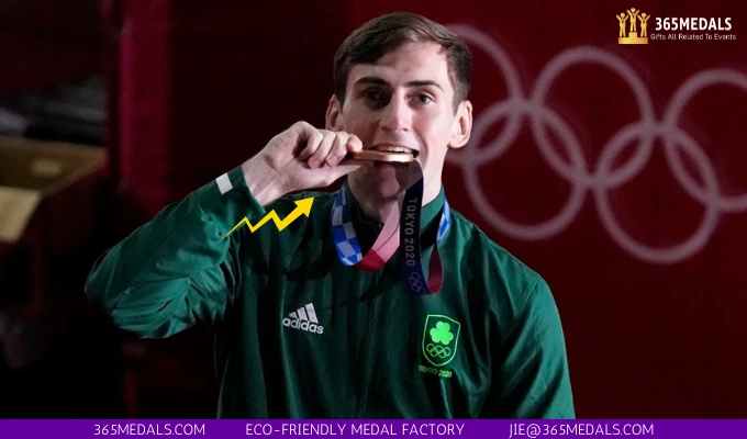 Ireland's Aidan Walsh bites his bronze medal